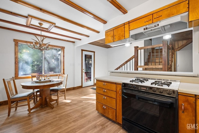 kitchen featuring black gas range, light wood-type flooring, decorative light fixtures, beam ceiling, and a chandelier