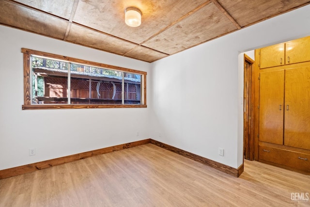 unfurnished bedroom with light hardwood / wood-style floors and wooden ceiling