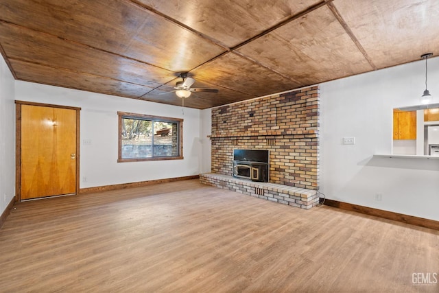 unfurnished living room with hardwood / wood-style flooring, ceiling fan, a wood stove, and wood ceiling