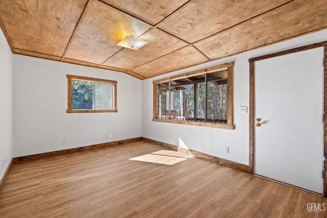 empty room featuring hardwood / wood-style flooring, lofted ceiling, a healthy amount of sunlight, and wood ceiling