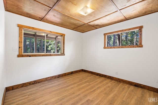 empty room featuring wood-type flooring and wooden ceiling