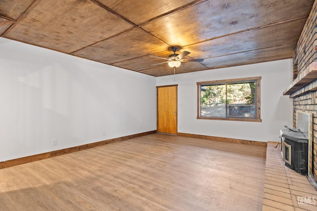 unfurnished living room with ceiling fan, light hardwood / wood-style floors, wood ceiling, and a wood stove