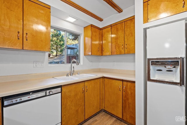 kitchen featuring white appliances, light hardwood / wood-style flooring, and sink