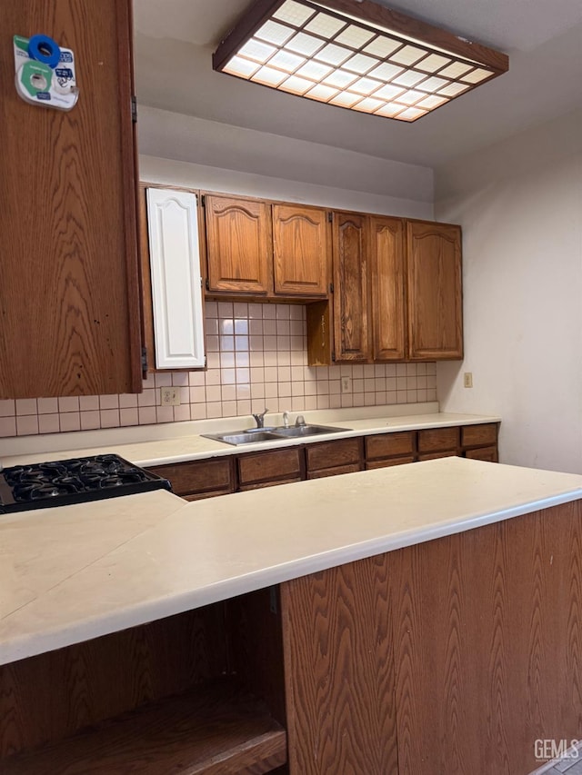1107 Monterey St, Bakersfield, CA 93305 - kitchen with light countertops, tasteful backsplash, brown cabinetry, and stovetop