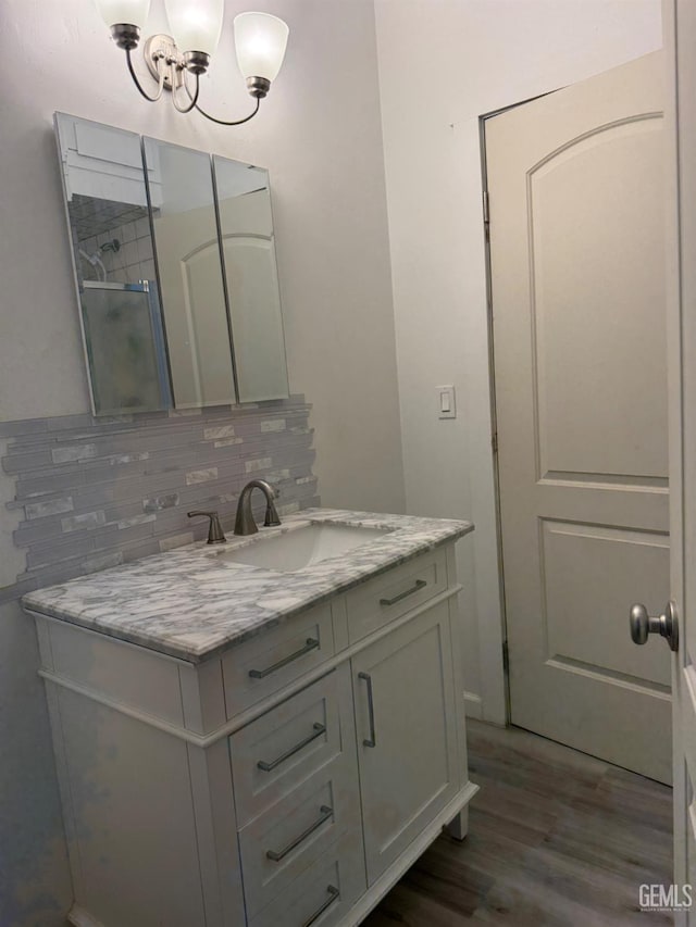 1107 Monterey St, Bakersfield, CA 93305 - bathroom featuring tasteful backsplash, vanity, wood finished floors, and a chandelier