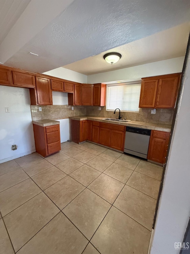 3600 O St Unit 22, Bakersfield, CA 93301 - kitchen featuring dishwasher, a sink, backsplash, and brown cabinetry