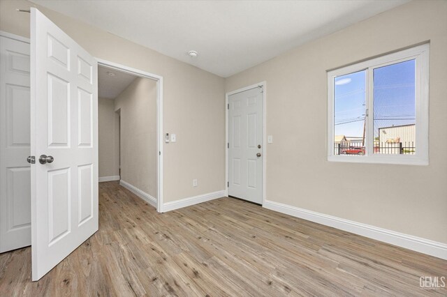 unfurnished room with light wood-style floors and baseboards