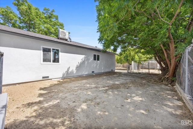 rear view of house with crawl space, fence, stucco siding, and central AC unit