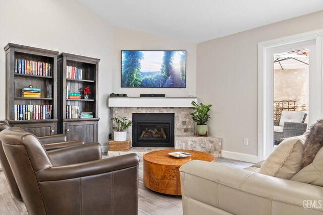 8220 Birmingham St, Bakersfield, CA 93311 - living area with lofted ceiling, light wood-style floors, a fireplace, and baseboards