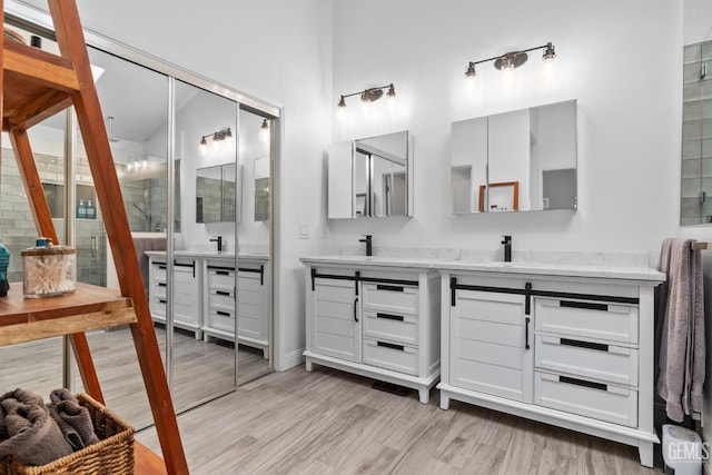 8220 Birmingham St, Bakersfield, CA 93311 - bathroom featuring double vanity, wood finished floors, a shower, and a towering ceiling