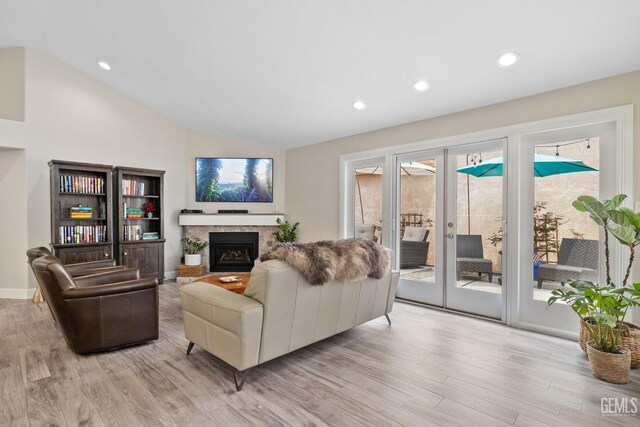 8220 Birmingham St, Bakersfield, CA 93311 - living room with light wood finished floors, a tiled fireplace, vaulted ceiling, recessed lighting, and french doors