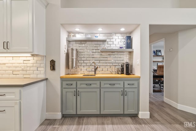 8220 Birmingham St, Bakersfield, CA 93311 - indoor wet bar featuring backsplash, baseboards, light wood-style flooring, and recessed lighting
