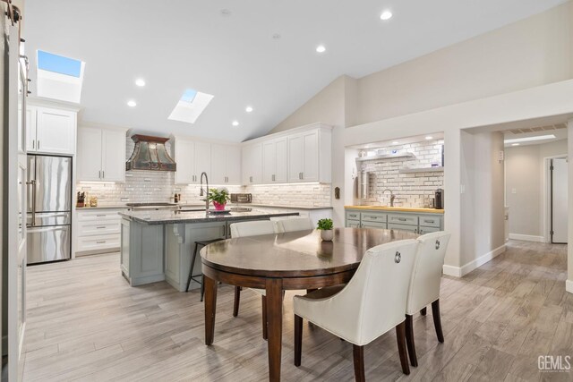 8220 Birmingham St, Bakersfield, CA 93311 - dining room featuring a skylight, lofted ceiling, light wood-type flooring, and recessed lighting