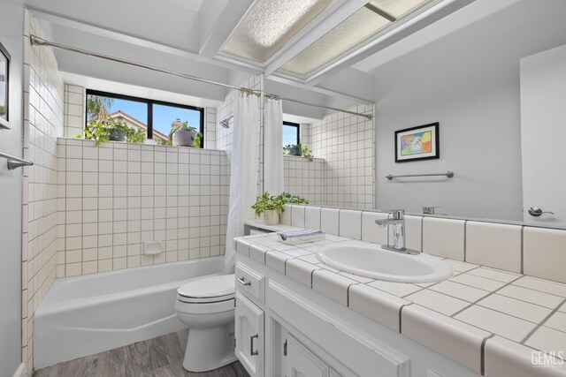 8220 Birmingham St, Bakersfield, CA 93311 - full bathroom with wood finished floors, vanity, toilet, and shower / tub combo with curtain