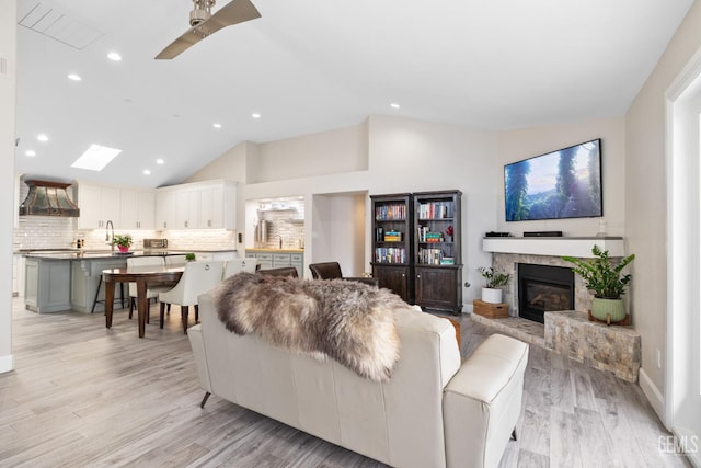 8220 Birmingham St, Bakersfield, CA 93311 - living area featuring lofted ceiling, light wood-style flooring, recessed lighting, a glass covered fireplace, and a ceiling fan