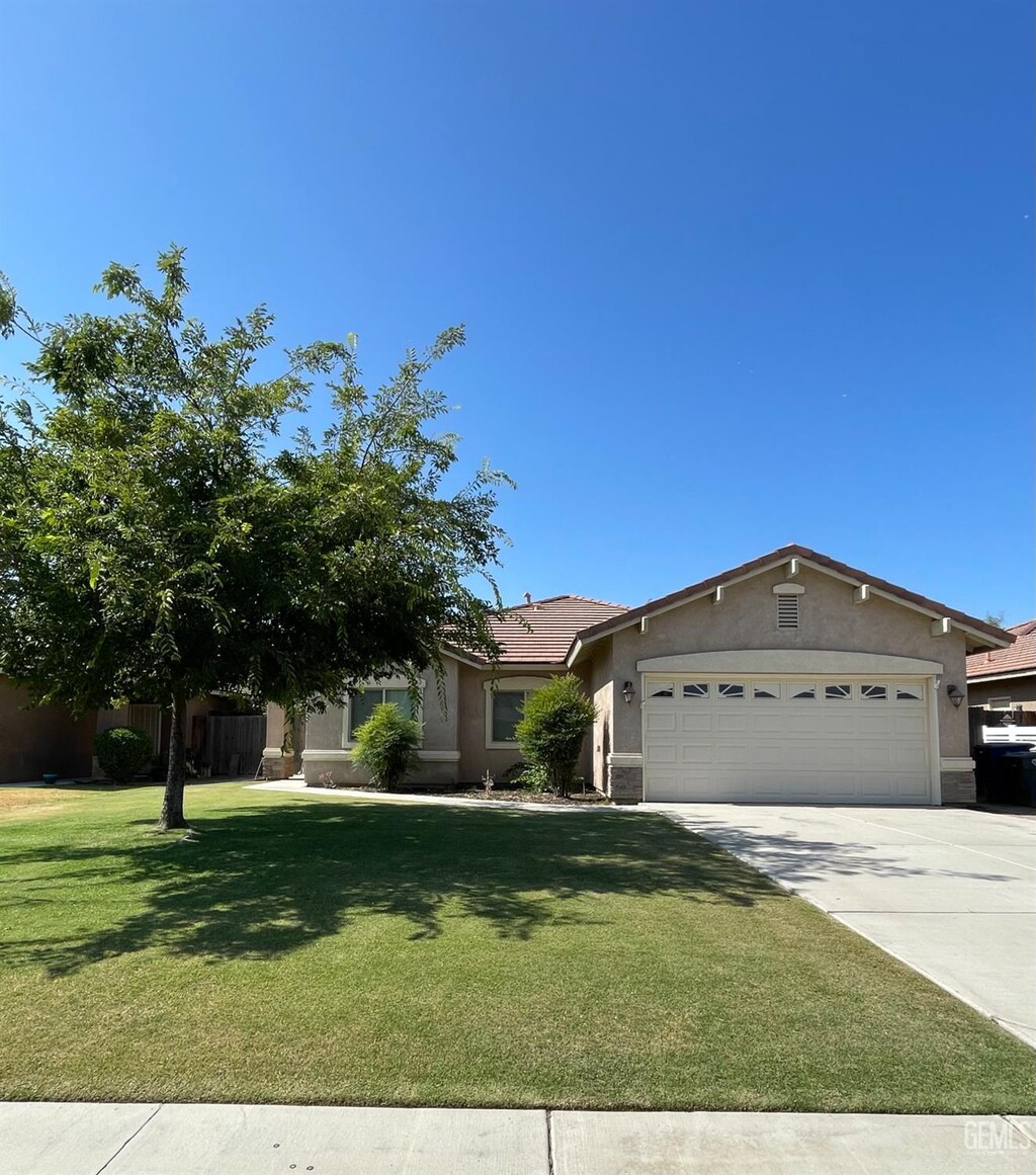 3513 Chisholm Trail Ave, Bakersfield, CA 93313 - view of front of home with stucco siding, a garage, and concrete driveway
