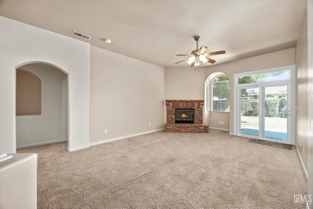 10200 Cheyenne Dr, Bakersfield, CA 93312 - unfurnished living room featuring light colored carpet, a ceiling fan, a brick fireplace, and arched walkways