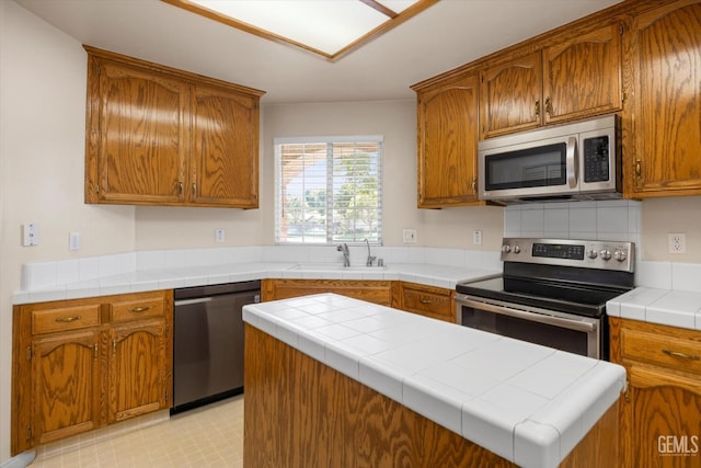 10200 Cheyenne Dr, Bakersfield, CA 93312 - kitchen with appliances with stainless steel finishes, brown cabinetry, and light floors