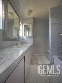 bathroom with vanity, tiled shower / bath, and tile patterned flooring