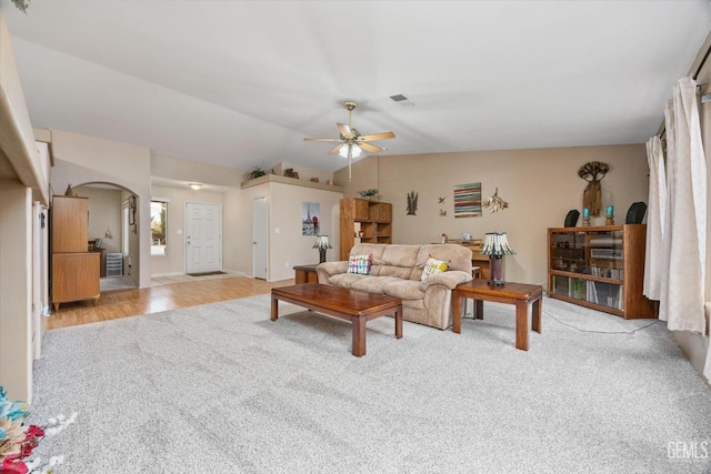 living room with light colored carpet, ceiling fan, and vaulted ceiling