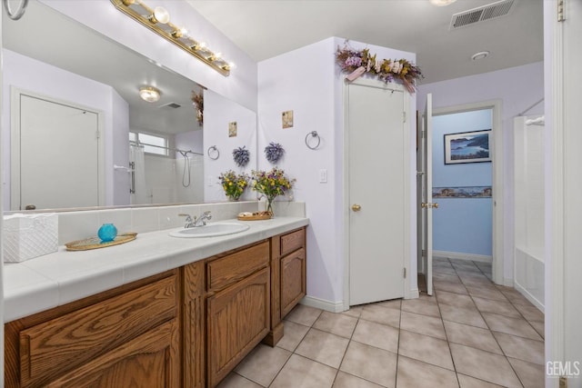 bathroom featuring tile patterned flooring, vanity, and bathing tub / shower combination