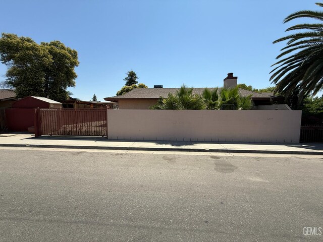 1328 Malerbi Ct, Bakersfield, CA 93307 - view of home's exterior featuring a gate and a chimney