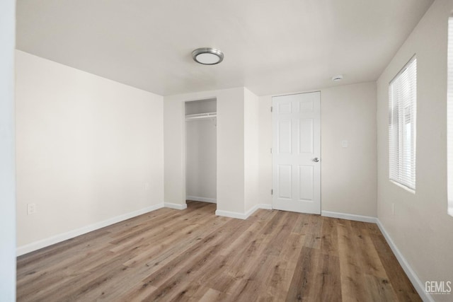 unfurnished bedroom with a closet and light hardwood / wood-style floors