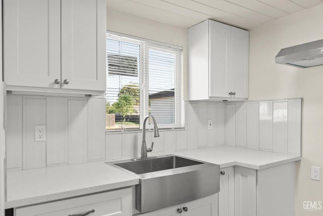 kitchen featuring tasteful backsplash, white cabinetry, sink, and wood ceiling