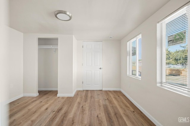 unfurnished bedroom with a closet and light hardwood / wood-style floors