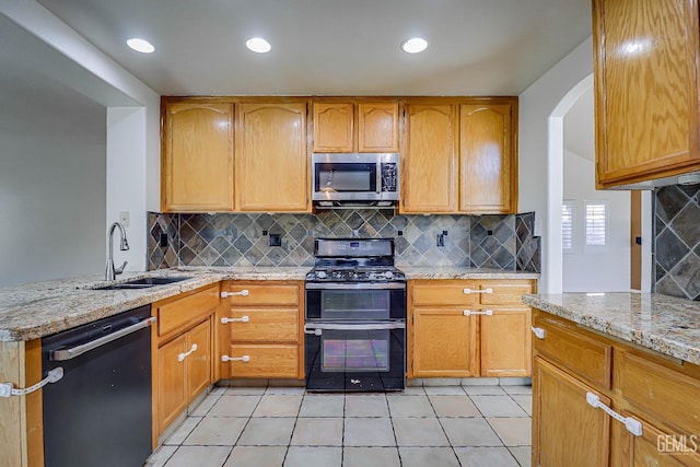 kitchen with light stone counters, sink, light tile patterned floors, and black appliances