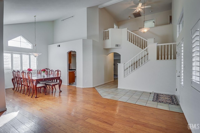 interior space with a towering ceiling, light hardwood / wood-style flooring, and ceiling fan