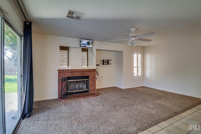 unfurnished living room with ceiling fan, a healthy amount of sunlight, carpet floors, and a fireplace