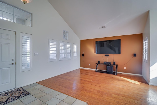 tiled foyer entrance featuring high vaulted ceiling