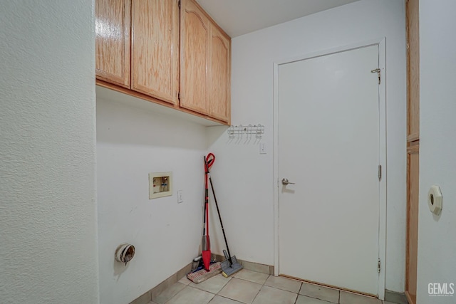 laundry area with cabinets, washer hookup, and light tile patterned floors