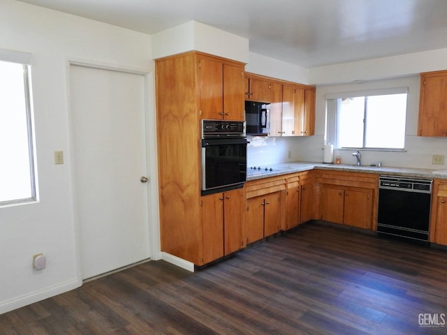 kitchen with dark wood-type flooring, black appliances, and sink