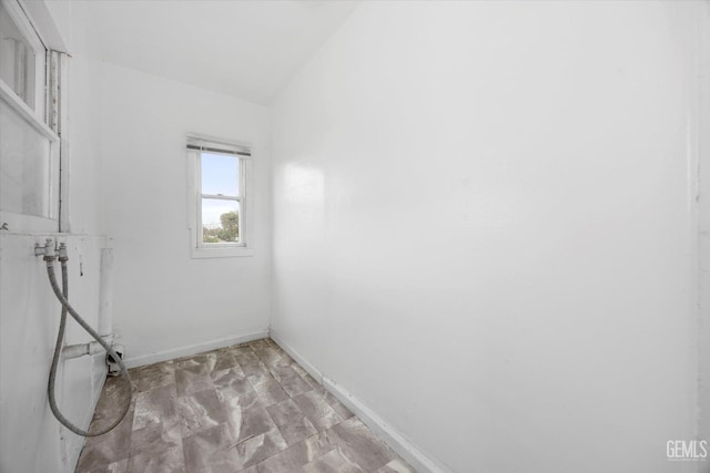 clothes washing area with laundry area and baseboards
