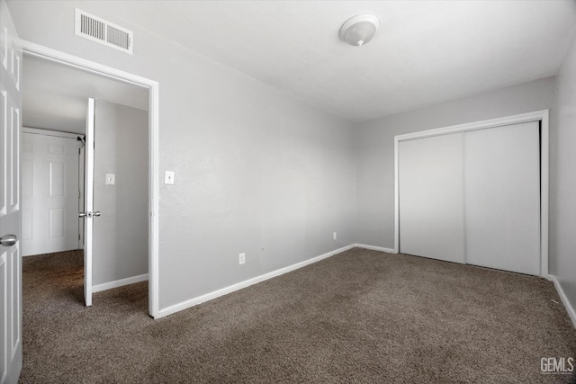 unfurnished bedroom featuring baseboards, a closet, visible vents, and carpet floors