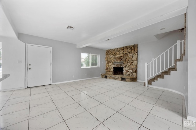 unfurnished living room with a stone fireplace, marble finish floor, visible vents, stairway, and beam ceiling