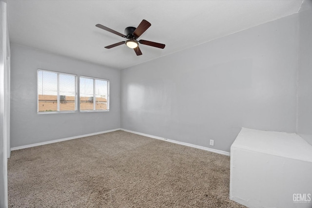 unfurnished room with carpet floors, a ceiling fan, and baseboards