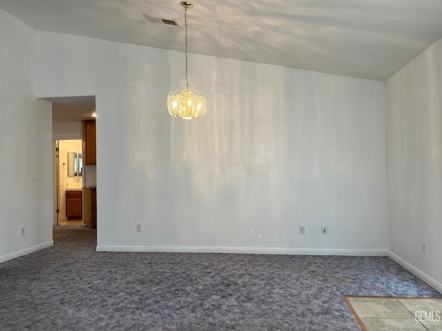 spare room featuring lofted ceiling, carpet floors, and a notable chandelier