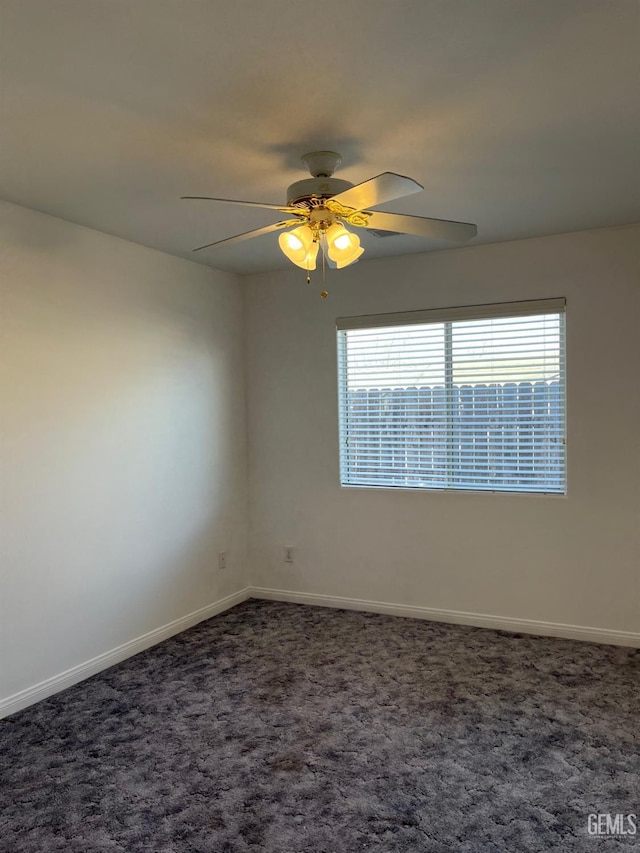 spare room with dark colored carpet and ceiling fan