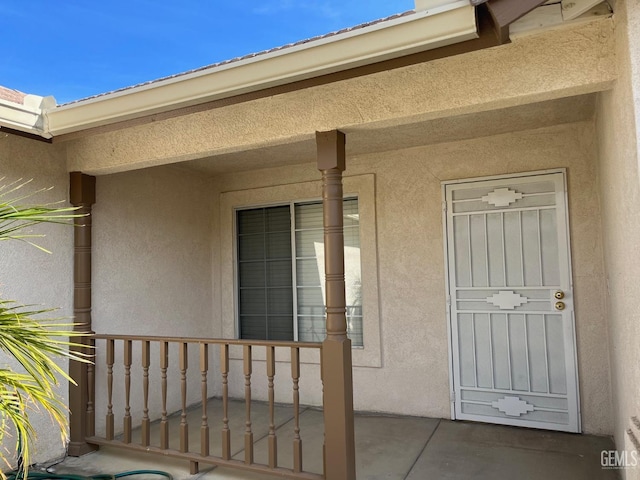 view of exterior entry featuring covered porch