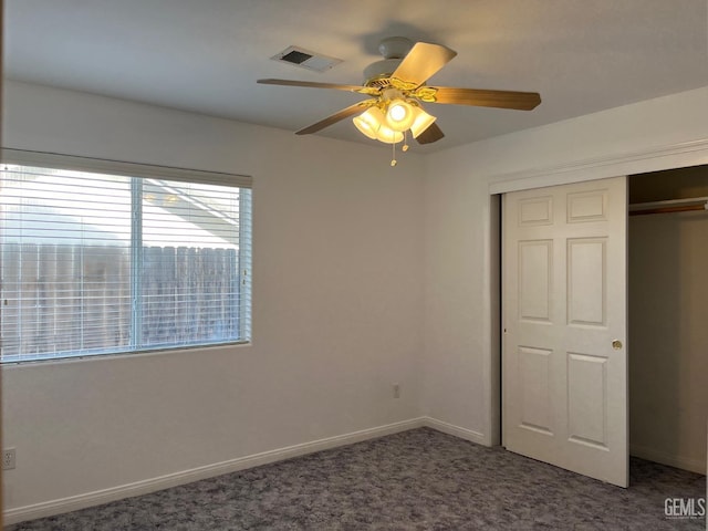 unfurnished bedroom with ceiling fan, a closet, and dark carpet