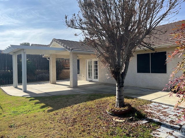 rear view of house featuring a lawn and a patio