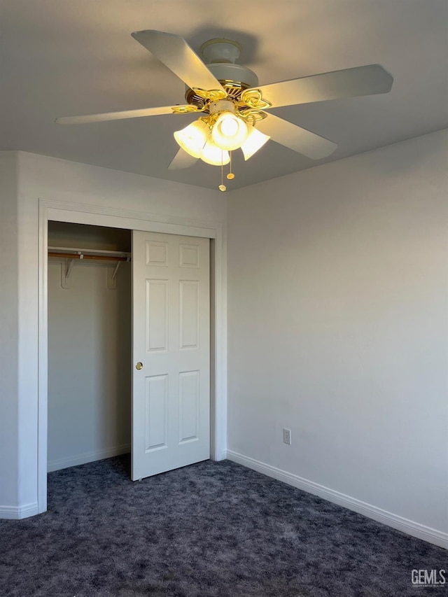 unfurnished bedroom featuring ceiling fan, a closet, and dark colored carpet