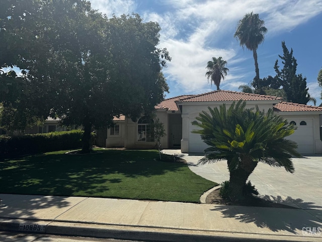 mediterranean / spanish-style house featuring a front lawn and a garage