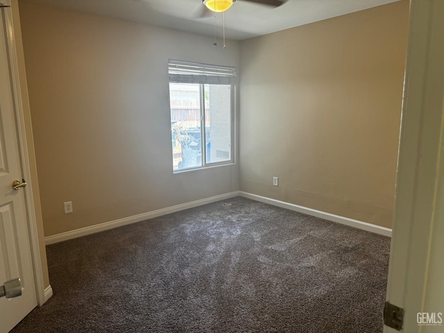 empty room featuring dark carpet and ceiling fan