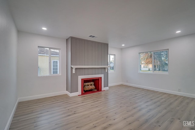 unfurnished living room with a fireplace, wood finished floors, visible vents, and recessed lighting