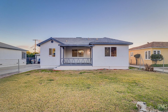 view of front of home with a front lawn, fence, and stucco siding