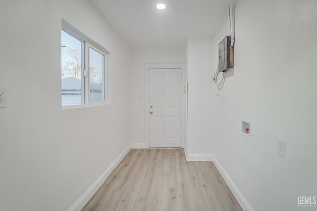 hallway with light wood-type flooring and baseboards